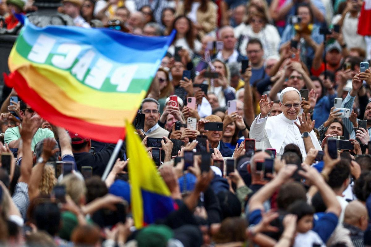 FILE PHOTO: A person holds a flag that reads "Peace" as Pope Leo XIV arrives for his first general audience in St. Peter's Square, at the Vatican, May 21, 2025. REUTERS/Guglielmo Mangiapane/File Photo