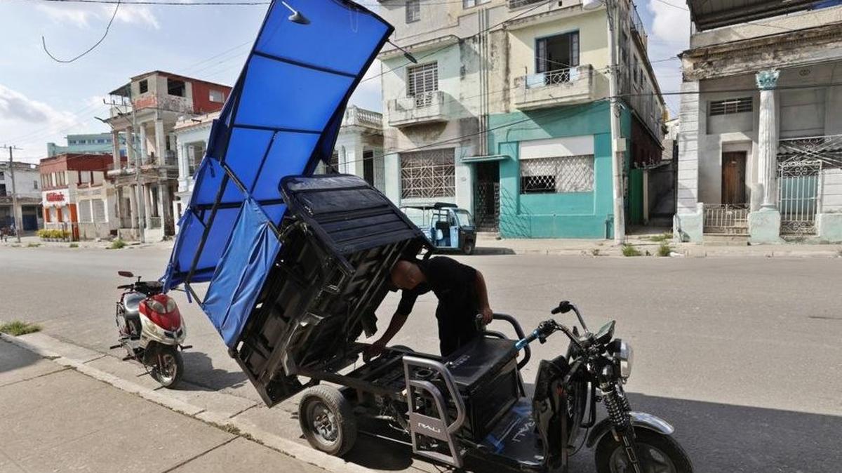 A person performs mechanical work on an electric tricycle in Havana on Thursday. The Cuban government acknowledged that the National Electric System is in critical share, with blackouts in Havana exceeding 22 hours a day in recent days, while in other provinces the outages have lasted two consecutive days. Photo by Ernesto Mastrascusa/EPA