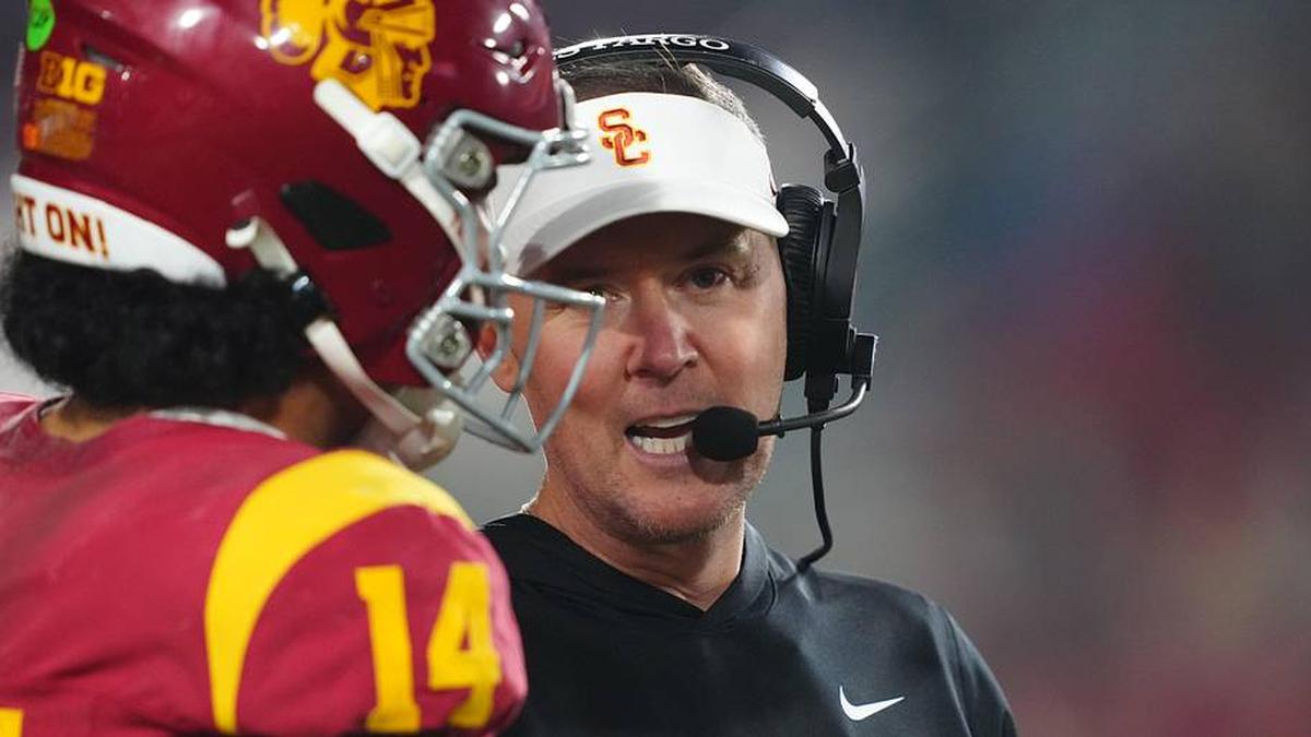  Nov 29, 2025; Los Angeles, California, USA; Southern California Trojans head coach Lincoln Riley (right) talks with quarterback Jayden Maiava (14) in the second half against the UCLA Bruins at United Airlines Field at Los Angeles Memorial Coliseum. Mandatory Credit: Kirby Lee-Imagn Images | Kirby Lee-Imagn Images 