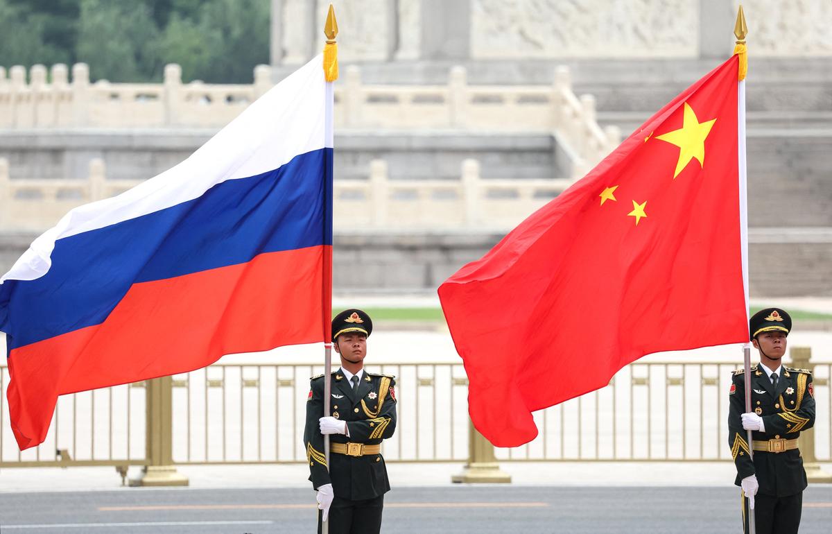 Chinese honor guards hold Russian and Chinese flags during a welcoming ceremony for Russian President Vladimir Putin at the Great Hall of the People in Beijing, China May 20, 2026. Sputnik/Alexander Kazakov/Pool via REUTERS