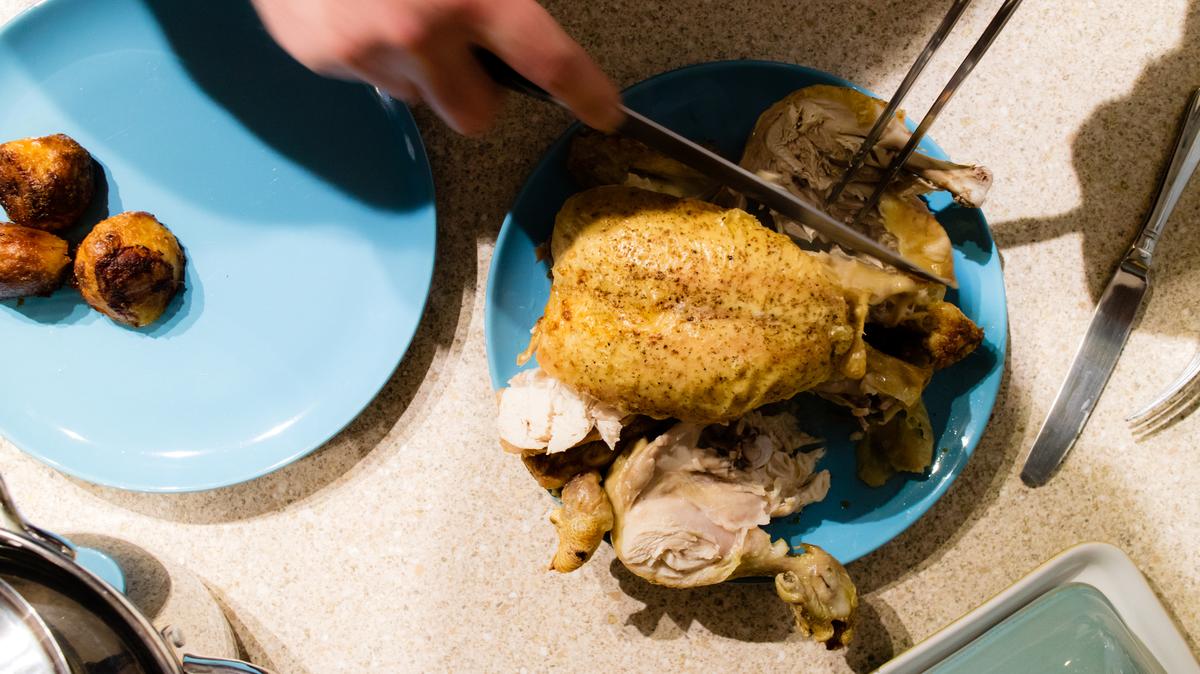 Top view of a freshly roasted chicken being carved.