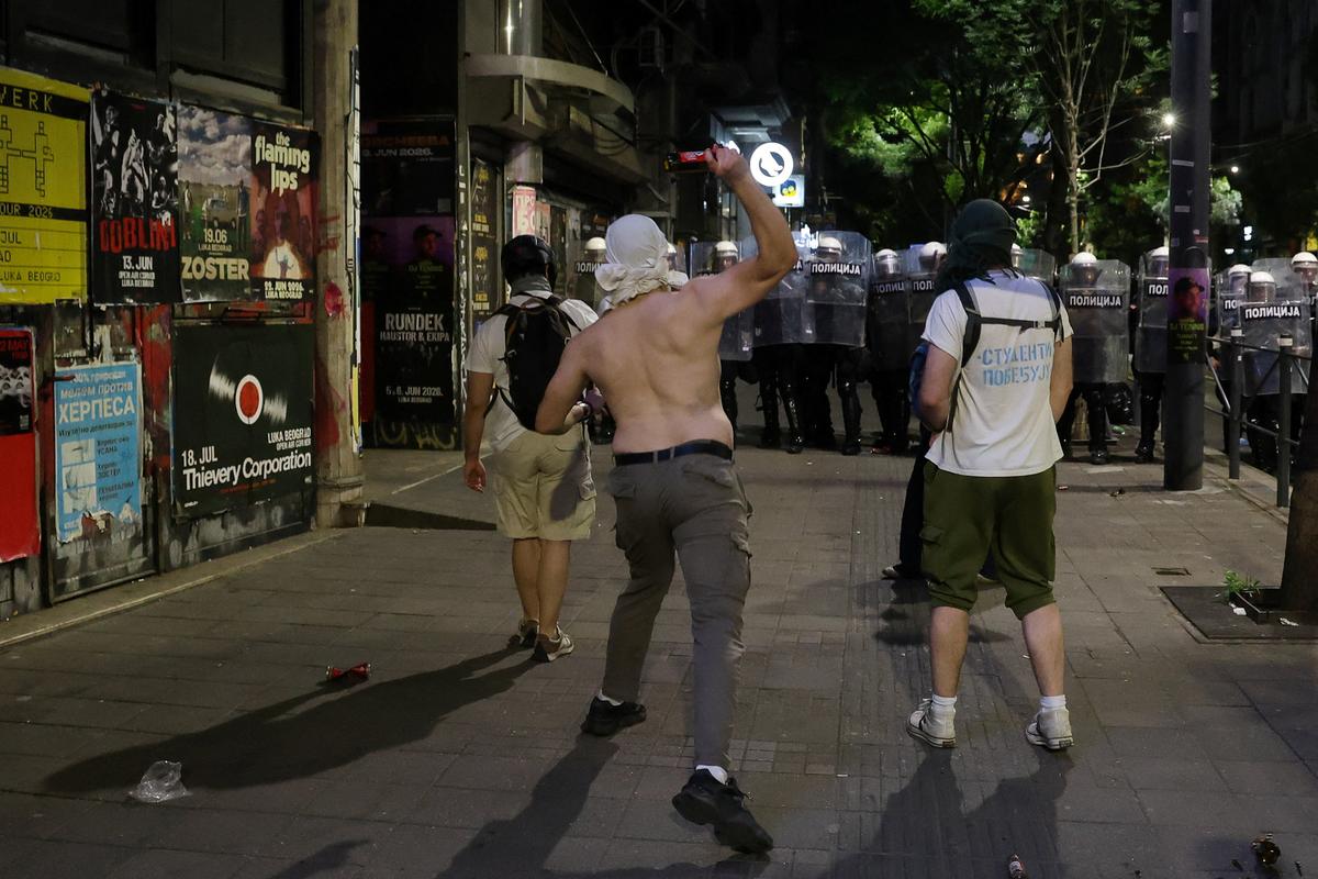 A demonstrator goes to throw a bottle towards riot police, during a student-led protest demanding snap parliamentary elections, as Serbia's anti-corruption movement enters a new phase, following the Novi Sad railway station canopy collapse that killed 16 people in 2024, in Belgrade, Serbia, May 23, 2026. REUTERS/Djordje Kojadinovic