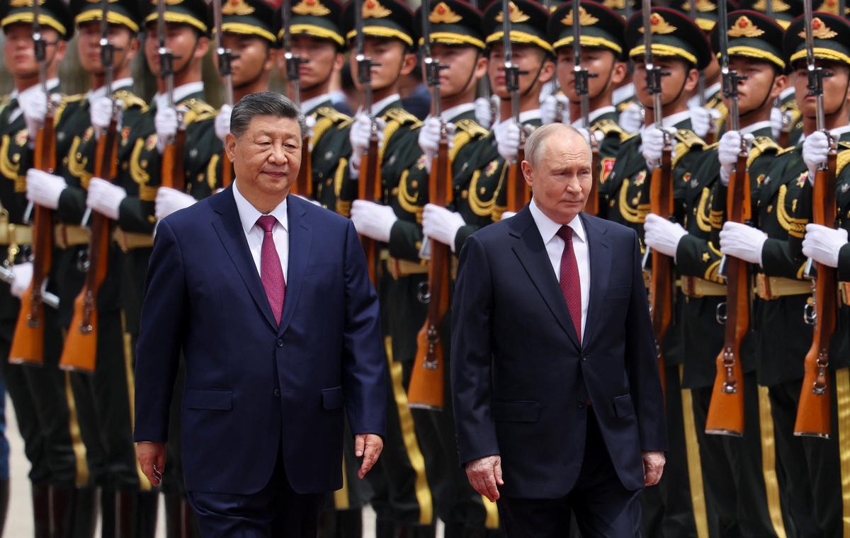 Russian President Vladimir Putin and Chinese President Xi Jinping inspect an honor guard during a welcoming ceremony at the Great Hall of the People in Beijing, China May 20, 2026. REUTERS/Maxim Shemetov/Pool