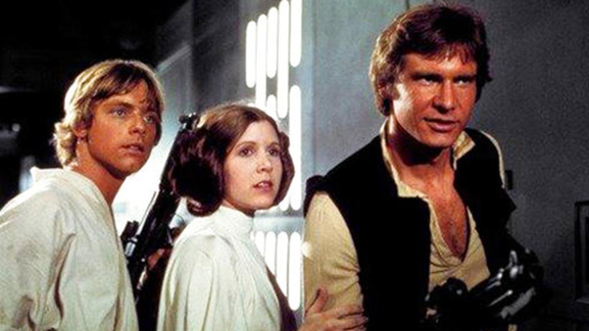 Mark Hamill, from left, as Luke Skywalker, Carrie Fisher as Princess Leia Organa, and Harrison Ford as Hans Solo in the original 1977 “Star Wars: Episode IV - A New Hope.”
