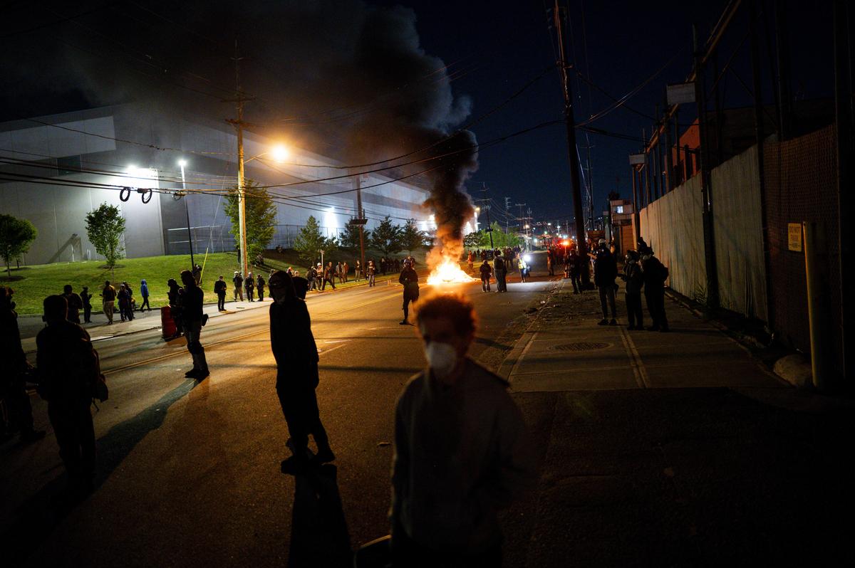 Demonstrators set debris on fire outside the Delaney Hall immigration detention center in Newark, N.J., May 30, 2026. Mayor Ras Baraka of Newark imposed a curfew early Sunday around the immigration detention center after a second consecutive night of unrest over living conditions there. (Vincent Alban/The New York Times)