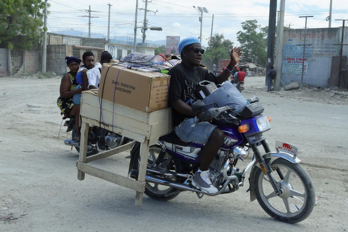 Residents transport their belongings on motorcycles while fleeing their homes in Cite Soleil after rival gang clashes in Haiti's capital worsened over the weekend, Port-au-Prince, Haiti, May 11, 2026. REUTERS/Fildor Pq Egeder
