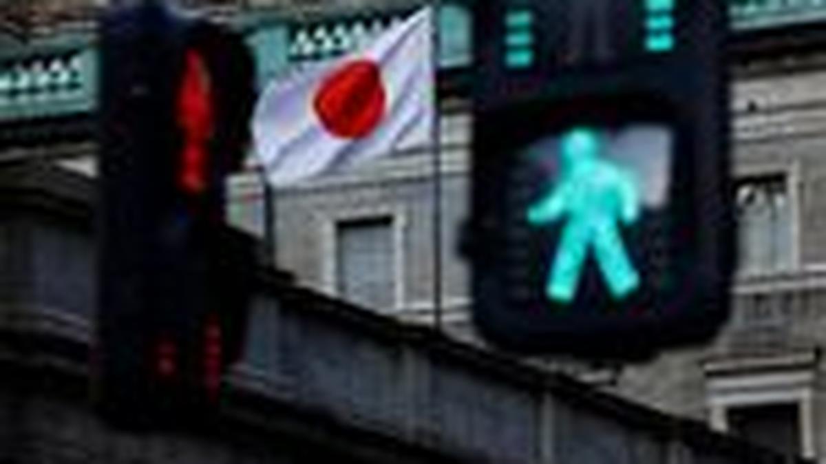 Japanese national flag hoisted atop of the Bank of Japan headquarters building is seen between traffic signals in Tokyo, Japan January 23, 2025.  REUTERS/Issei Kato