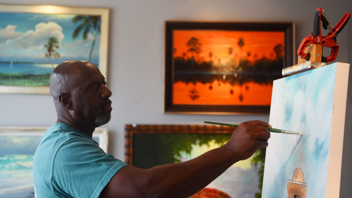 Ray McLendon works in a style known as Florida Highwaymen art, named after a group of black artists who painted vibrant Florida landscapes and sold their paintings up and down U.S. 1 from the 1950s to the 1980s. Photo taken July 2019.
