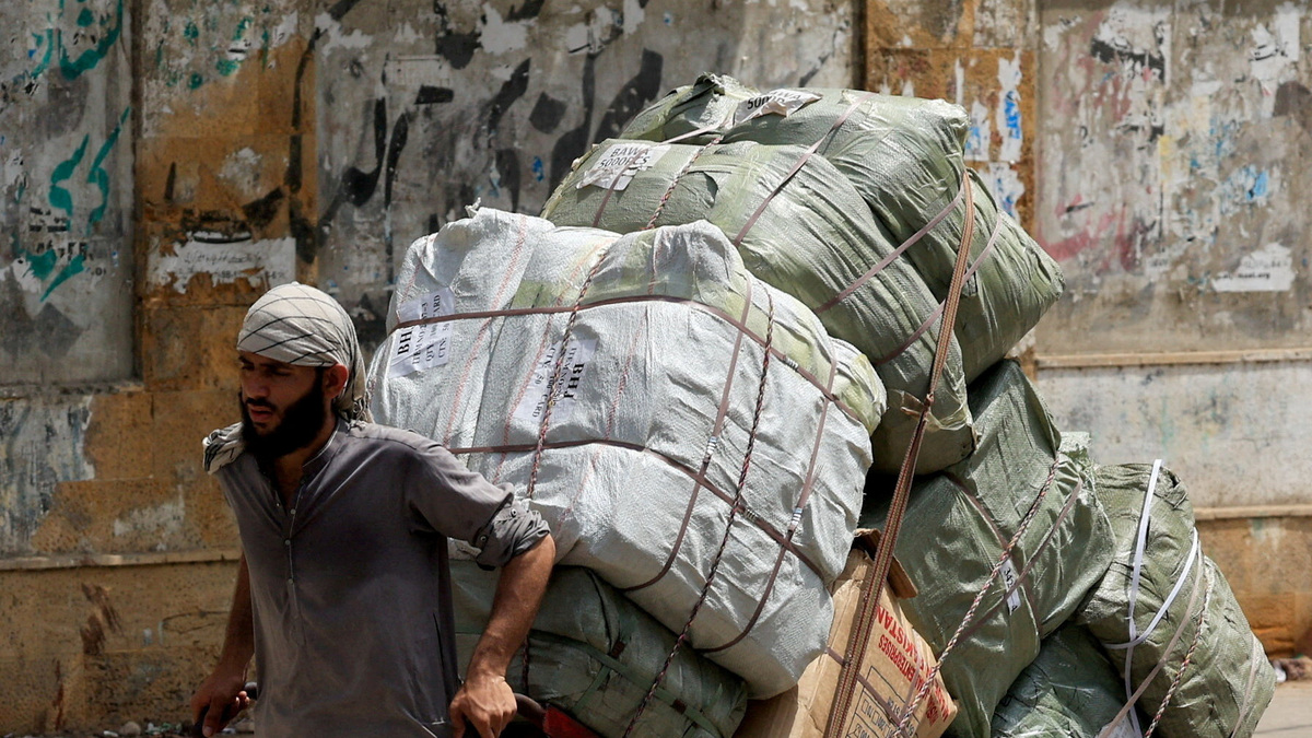 FILE PHOTO: A labourer pulls a trolley with supplies to deliver to a nearby market in Karachi, Pakistan June 4, 2026. REUTERS/Akhtar Soomro/File Photo