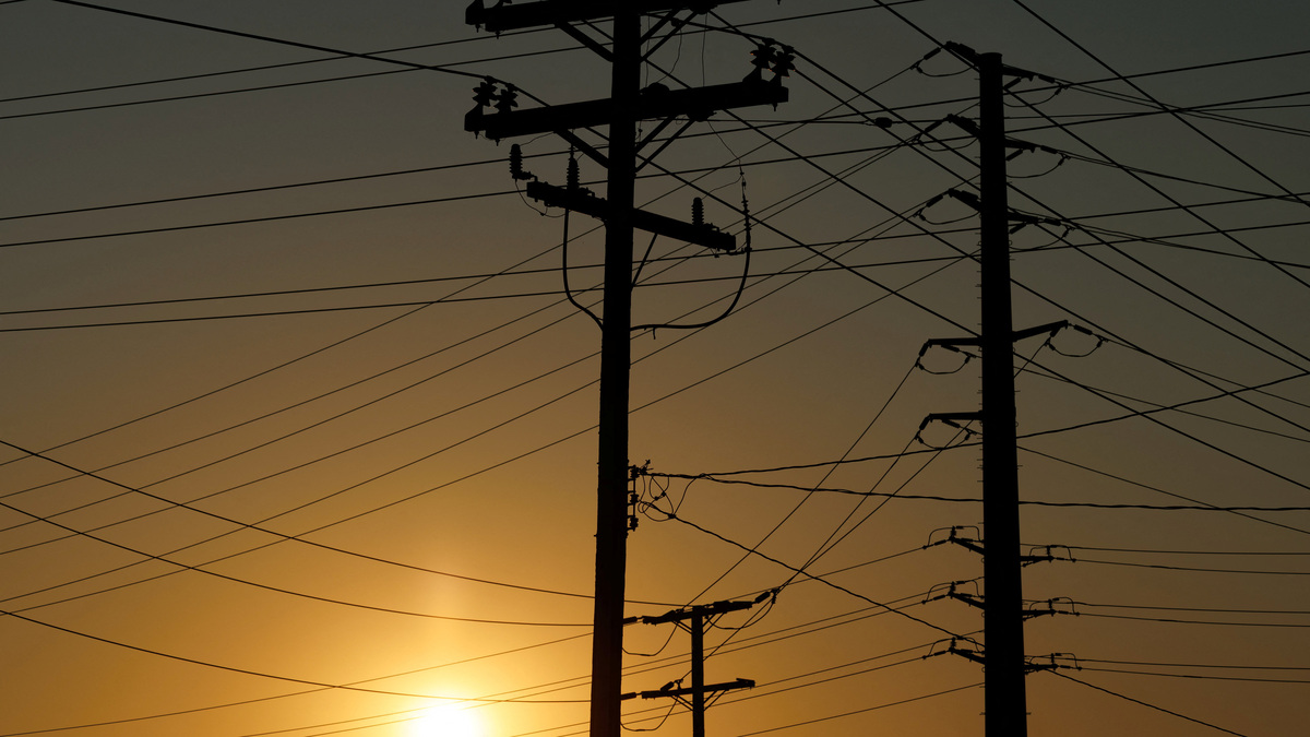 Electrical transmission poles and lines are shown in the early morning of a hot summer day in Commerce, California, U.S, August 7, 2025.  REUTERS/Mike Blake