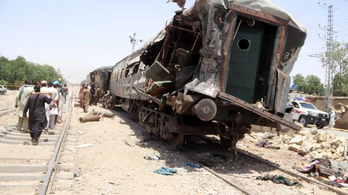 People walk along the railway tracks next to wrecked carriages at the scene of a deadly train blast in Quetta, Pakistan, on Sunday. Photo by Fayyaz Ahmed/EPA