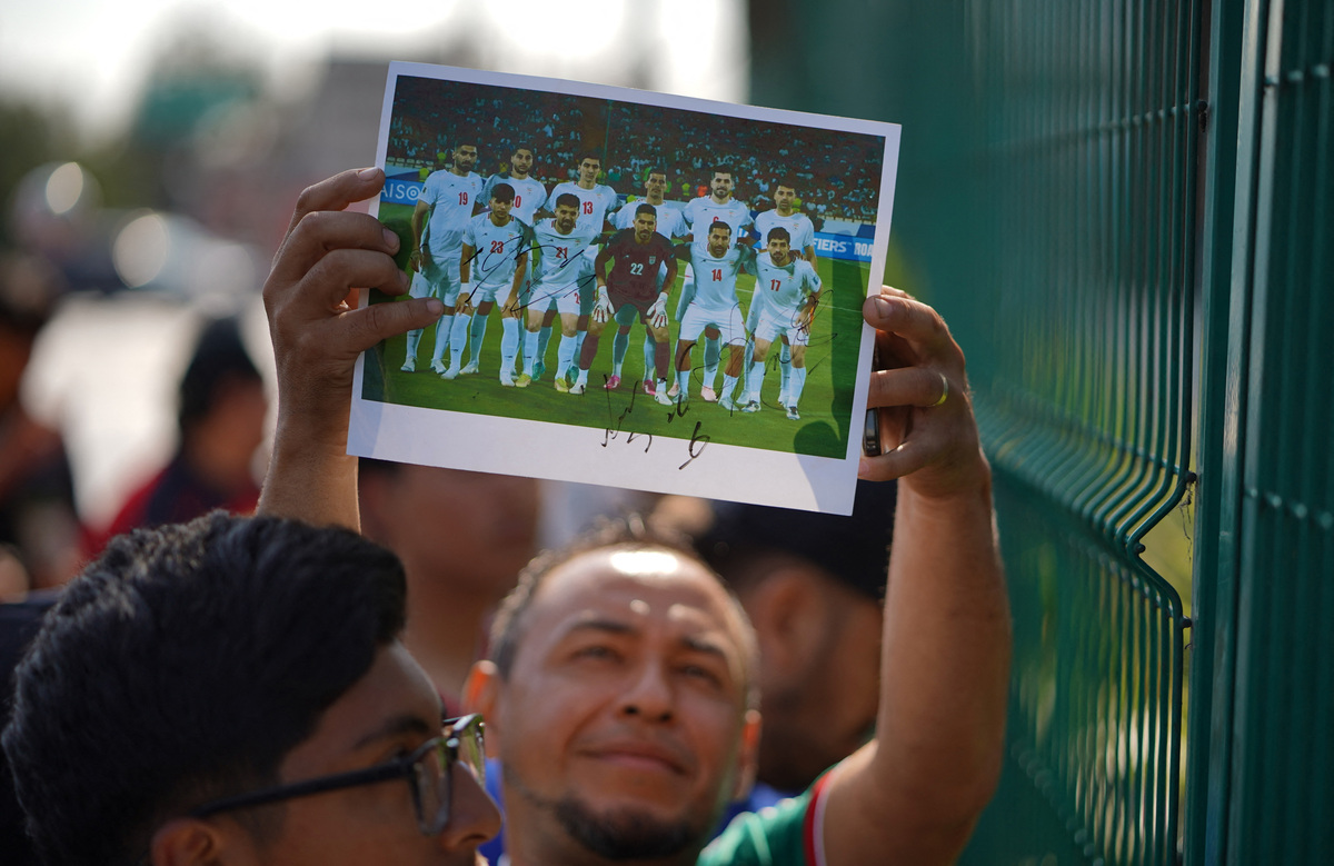Soccer Football - FIFA World Cup 2026 - Iran leave Tijuana hotel ahead of first World Cup match - Tijuana, Mexico - June 14, 2026 A fan with a signed photo of the Iran squad outside the hotel before the match REUTERS/Victor Medina