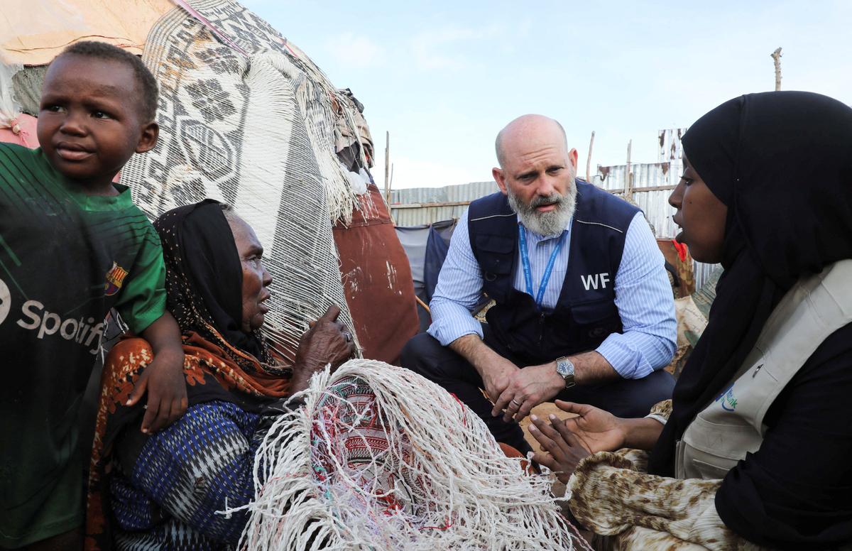 The World Food Programme’s Assistant Executive Director for Programme Operations, Matthew Hollingworth, talks to civilians during his visit to a camp for the internally displaced people to assess the knock on effects from the escalation in the Middle East, alongside drought and sharp cuts in humanitarian funding that are worsening hunger, in Kahda district of Mogadishu, Somalia May 7, 2026. REUTERS/Feisal Omar