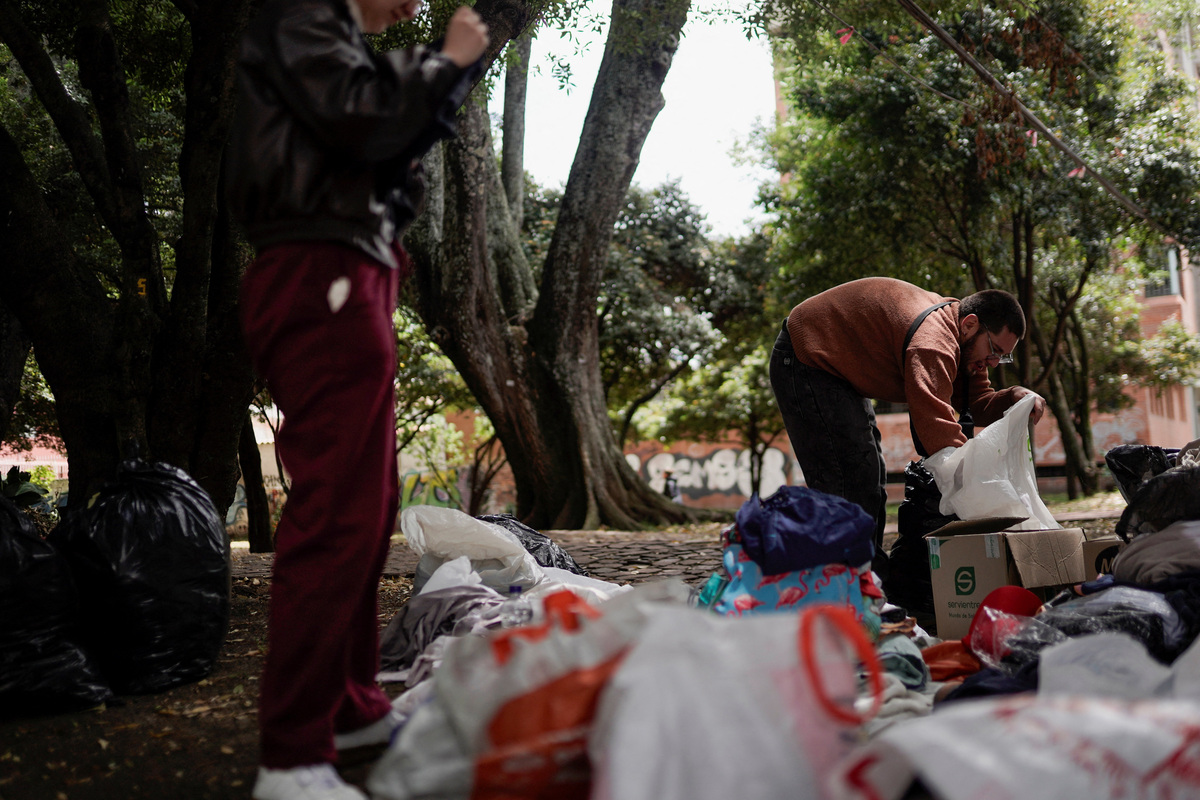 A man looks inside a bag as aid donations are collected and organised for people in Venezuela affected by recent earthquakes, in Bogota, Colombia, June 26, 2026. REUTERS/Sergio Acero