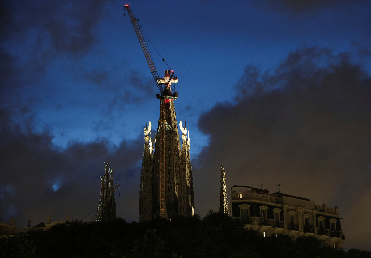 A building with lights on sits next to the Sagrada Familia basilica, designed by Catalan architect Antoni Gaudi, ahead of Pope Leo XIV's visit to Barcelona, Spain, June 5, 2026. REUTERS/Nacho Doce