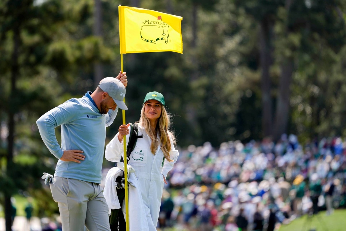  Apr 8, 2026; Augusta, Georgia, USA; Wyndham Clark and his girlfriend Alicia Bogdanski stands with the pin flag on the second hole during the Par 3 Contest at the Masters Tournament at Augusta National Golf Club. Mandatory Credit: Katie Goodale-Imagn Images 