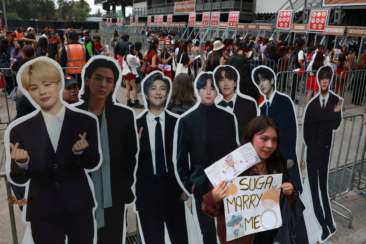 FILE PHOTO: A fan poses with cardboard cutouts as they gather outside the venue before South Korean Kpop boy band BTS's concert, as the bond between Korea and Mexico, one of the world’s more unusual geo-cultural connections, continues to grow, with Korean influence gaining a foothold despite distance, language barriers and a 15-hour time difference, in Mexico City, Mexico, May 7, 2026. REUTERS/Henry Romero/File Photo