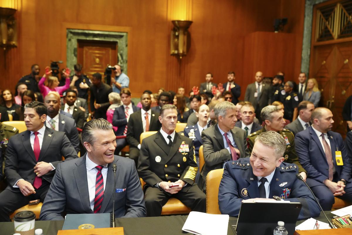 Defense Secretary Pete Hegseth, left, and Gen. Dan Caine, the chairman of the Joint Chiefs of Staff, share a moment before testifying at a Senate Appropriations Subcommittee on Defense hearing on the Department of Defense's budget request on Capitol Hill in Washington, on Tuesday, May 12, 2026. (Tierney L. Cross/The New York Times)