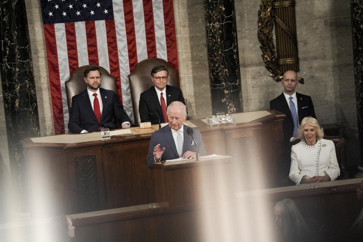 King Charles III, with Queen Camilla seated right, addresses a joint meeting of Congress in honor of the 250th anniversary of American independence at the Capitol in Washington, on Tuesday, April 28, 2026. Vice President JD Vance, left, and House Speaker Mike Johnson (R-La.) sit behind him. (Salwan Georges/The New York Times)