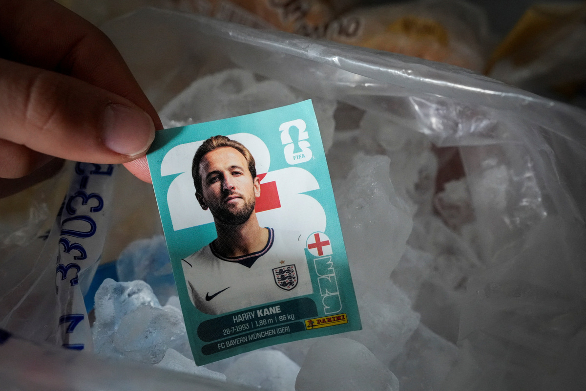 Una argentina sostiene una tarjeta coleccionable de Harry Kane antes de colocarla en el congelador, como parte de sus rituales previo al partido de Argentina contra Inglaterra, el 13 de julio de 2026 en Buenos Aires.