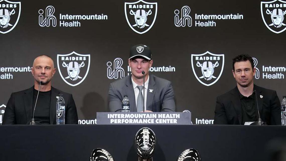  Apr 24, 2026; Henderson, NV, USA; Las Vegas Raiders quarterback Fernando Mendoza (center) speaks at introductory press conference at Intermountain Healthcare Performance Center flanked by general manager John Spytek (left) and head coach Klint Kubiak after being selected as the No. 1 pick in the 2026 NFL Draft. Mandatory Credit: Kirby Lee-Imagn Images | Kirby Lee-Imagn Images 