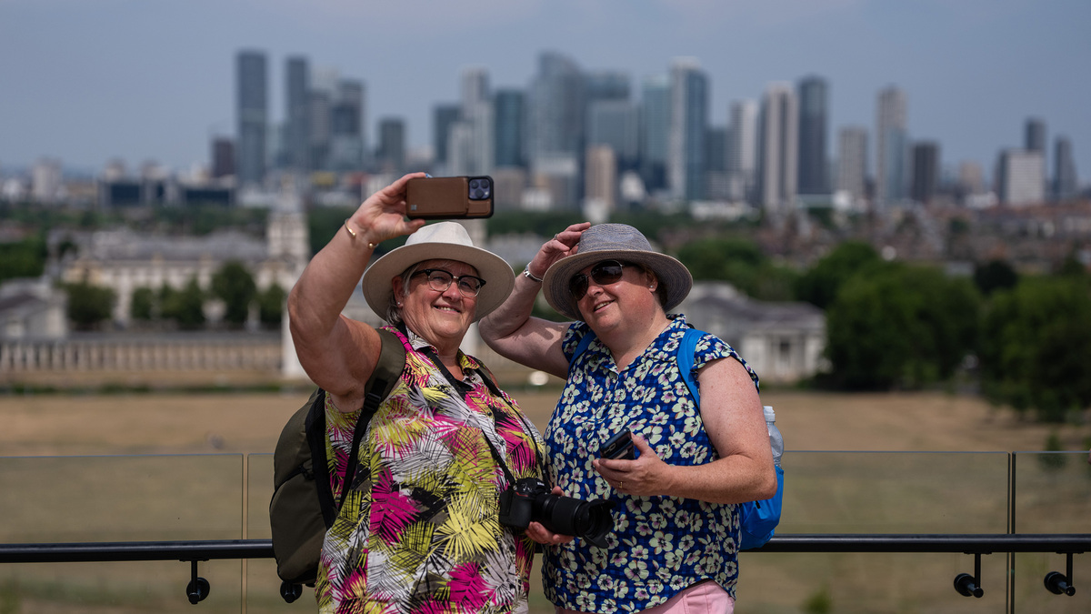 People take a selfie as they visit Greenwich Park on July 10, 2026, in London. Britain's Health Security Agency has issued yellow heat health alerts for the Midlands, eastern and southern England through to 12 July as temperatures are forecast to build into heat wave conditions. For some regions affected, the hot spell could mark the third official heat wave of the season, following record-breaking temperatures in May and June.  (Carl Court/Getty Images/TNS)