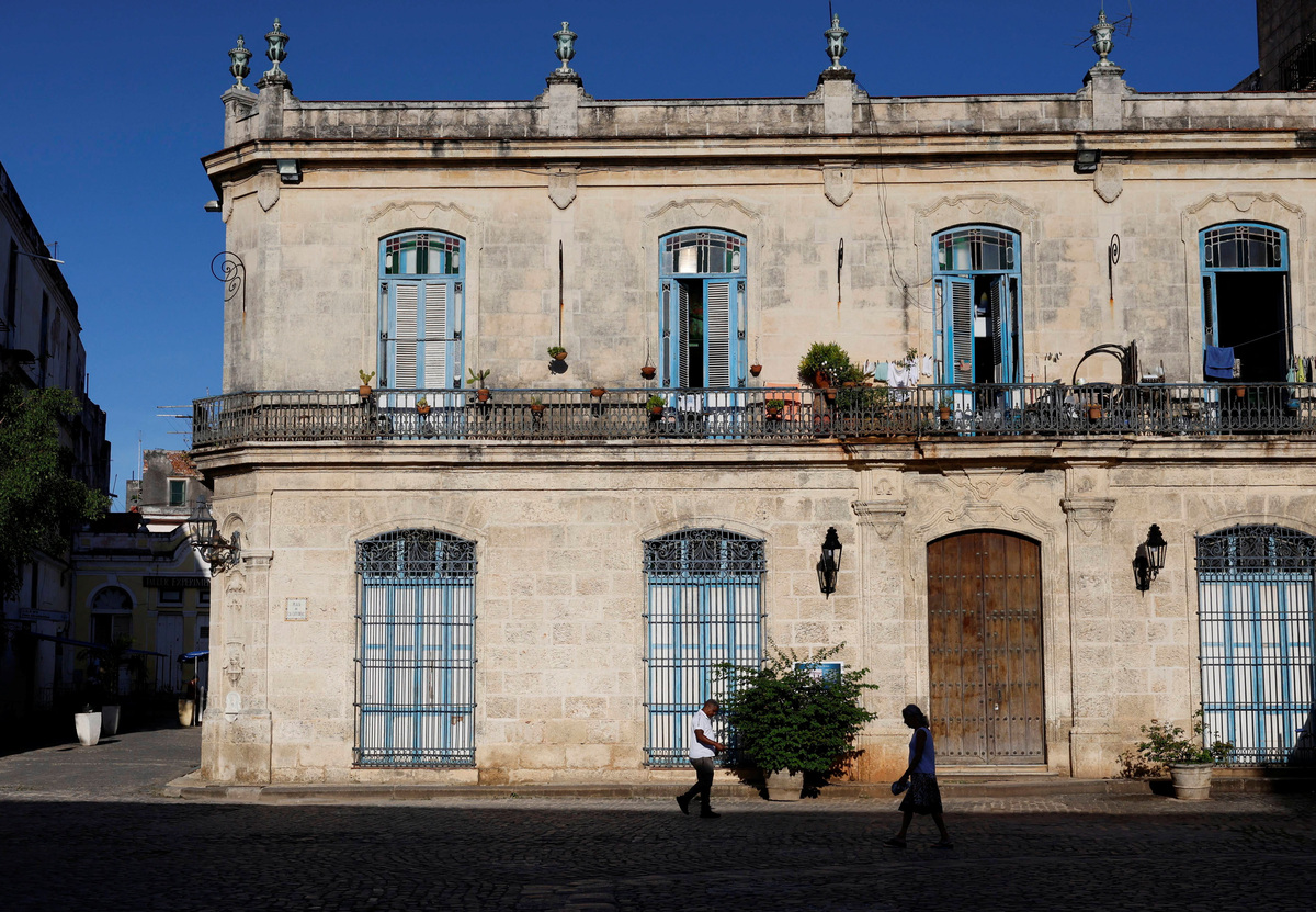 People walk in front of a colonial-era building at Cathedral Square, one of the most popular tourist spots in the city, as U.S. sanctions have led most major tourism and travel companies to leave the island or drastically scale back their operations, in Havana, Cuba June 8, 2026. REUTERS/Norlys Perez