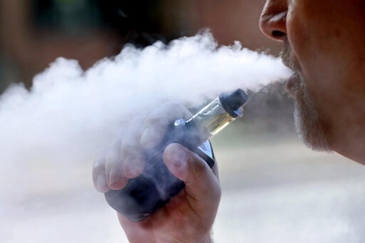 A man exhales while smoking an e-cigarette in Portland, Maine, in August.