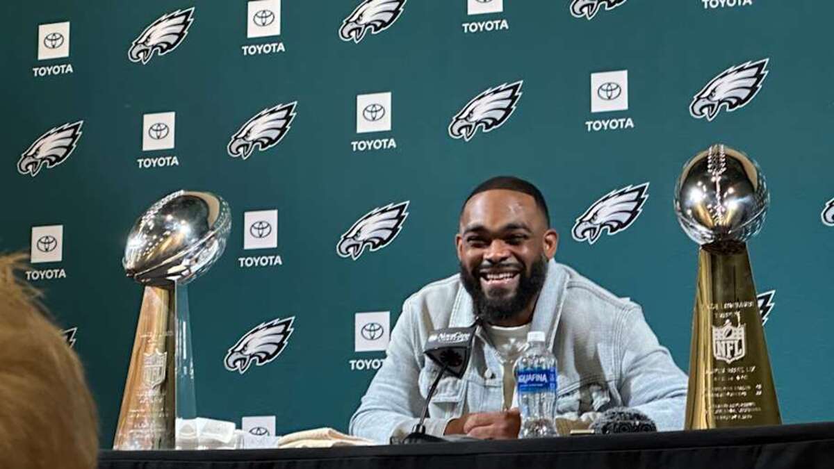  Framed by the two Lombardi Trophies he helped deliver to the Eagles, Brandon Graham smiles during his retirement press conference on March 18, 2025. | Ed Kracz/Eagles on SI 