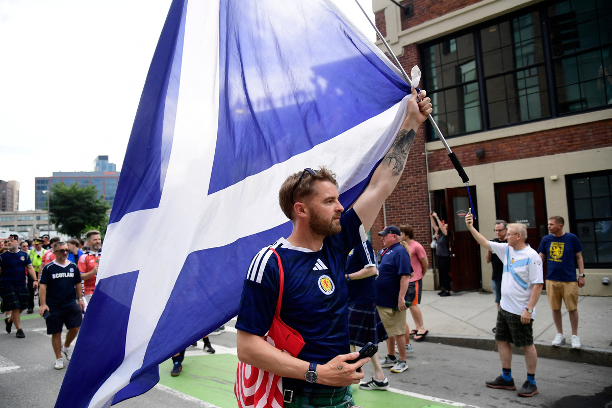 Soccer Football - FIFA World Cup 2026 - Scotland's Tartan Army march to Boston's Fenway Park baseball stadium - Boston, Massachusetts, U.S. - June 14, 2026 A Scotland fan displays the national flag during the march to Fenway Park IMAGN IMAGES via Reuters/Bob Dechiara