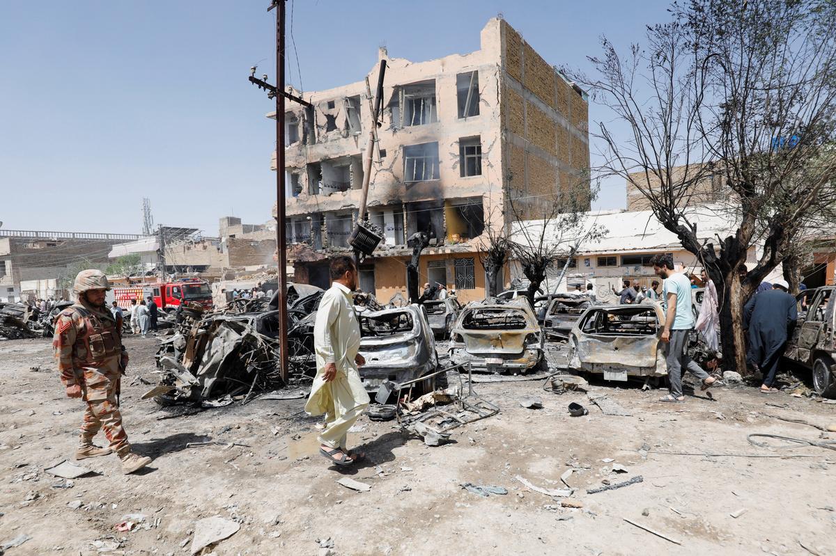 A paramilitary soldier walks past the damaged vehicle, after a blast near a railway track in Quetta, Pakistan May 24, 2026. REUTERS/Naseer Ahmed