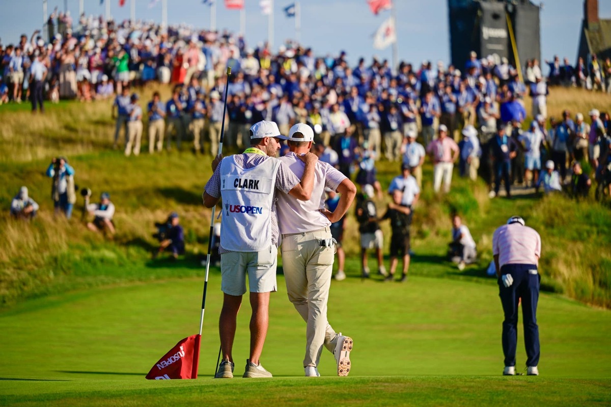  Wyndham Clark, right, with his caddie, David Pelekoudas, on the 18th hole green during the final round of the 2026 U.S. Open at Shinnecock Hills Golf Club in Southampton, N.Y. on Sunday, June 21, 2026. (Logan Whitton/USGA)