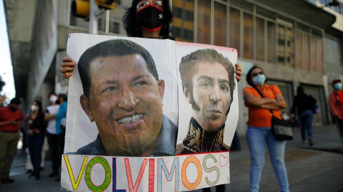 Simpatizantes del régimen chavista muestran imágenes del fallecido presidente Hugo Chavez y el Libertador Simón Bolívar frente a la Asamblea Nacional, el 5 de enero de 2021 en Caracas, Venezuela, para celebrar el regreso del oficialismo al parlamento.