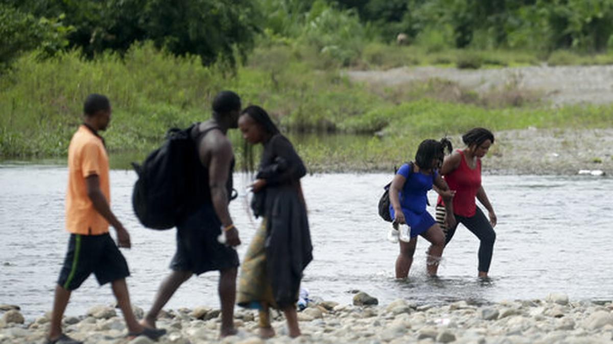 Dos mujeres cruzan el río Tuquesa después de pasar por la jungla Bajo Chiquito, en la provincia Darién, Panamá, el 25 de mayo de 2019. Darién es una región en donde inmigrantes con la intención de llegar a Estados Unidos se reúnen y establecen un campamento.