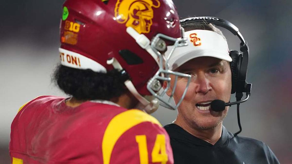  Nov 29, 2025; Los Angeles, California, USA; Southern California Trojans head coach Lincoln Riley (right) talks with quarterback Jayden Maiava (14) in the second half against the UCLA Bruins at United Airlines Field at Los Angeles Memorial Coliseum. Mandatory Credit: Kirby Lee-Imagn Images | Kirby Lee-Imagn Images 