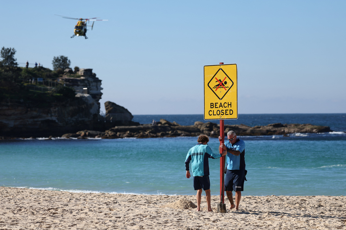 Lifeguards erect a sign that says "Beach Closed" following a shark attack at Coogee Beach in Sydney, Australia, June 13, 2026. REUTERS/Hollie Adams