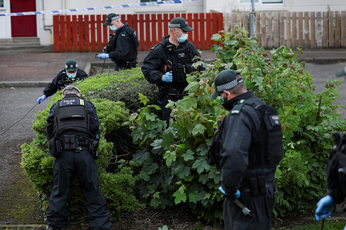 Police officers inspect the area near the scene of a stabbing outside apartments in the Kinnaird Avenue area of north Belfast, after a knife attack on June 8 left a man seriously injured and prompted police to declare a critical incident, in Belfast, Northern Ireland, June 9, 2026. REUTERS/Isabel Infantes