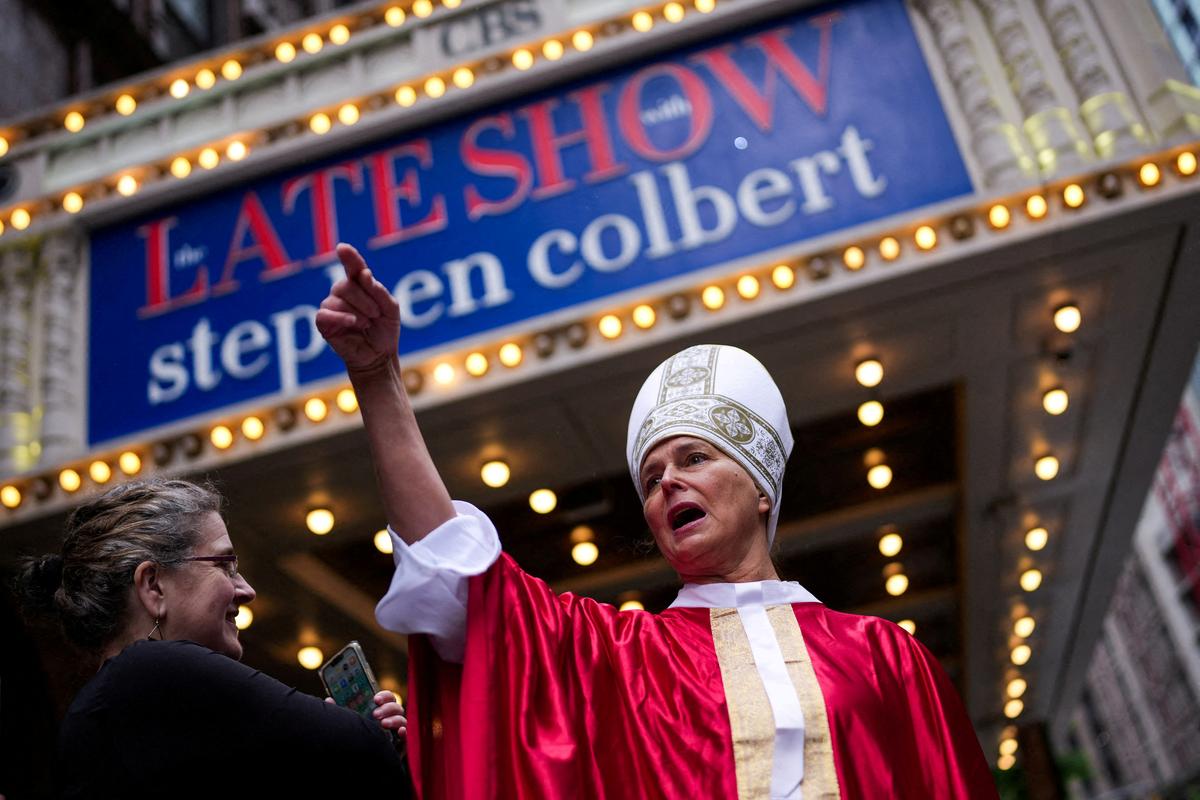 FILE PHOTO: Brenda Ellis, 62, gestures dressed as the Pope outside of the Ed Sullivan Theater before the taping of the final episode of the "The Late Show" with Stephen Colbert, in New York City, U.S., May 21, 2026. REUTERS/Adam Gray     TPX IMAGES OF THE DAY/File Photo