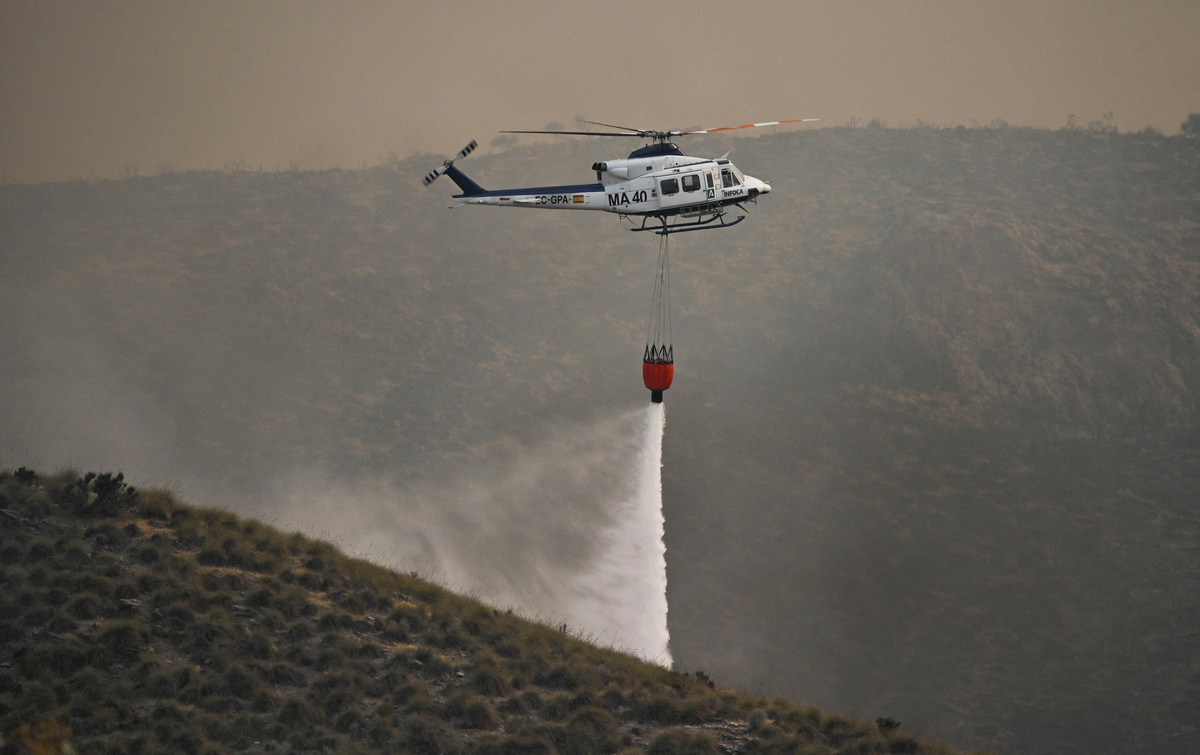 A firefighting helicopter dumps water over a wildfire in Los Gallardos, Almeria, Spain, July 10, 2026. REUTERS/Stringer