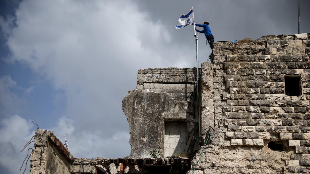 An Israeli settler places an Israeli flag, on the day of the re-establishment of the settlement of Sa-Nur, which was evacuated as part of Israel’s 2005 disengagement, in Sa-Nur in the Israeli-occupied West Bank, April 19, 2026. REUTERS/Shir Torem