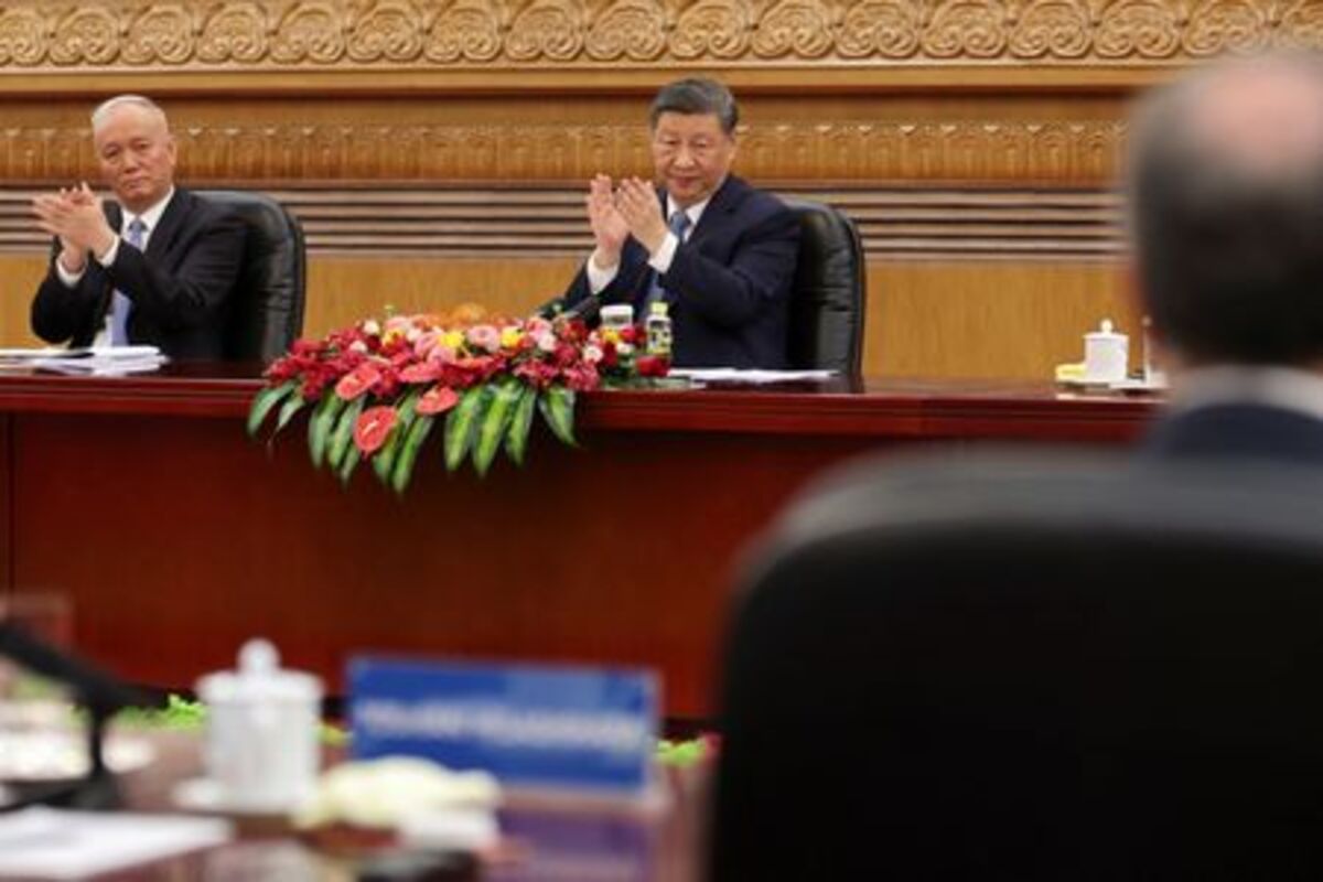 Chinese President Xi Jinping applauds next to Politburo Standing Committee member Cai Qi at a meeting with foreign business leaders at the Great Hall of the People in Beijing, China March 28, 2025. REUTERS/Florence Lo