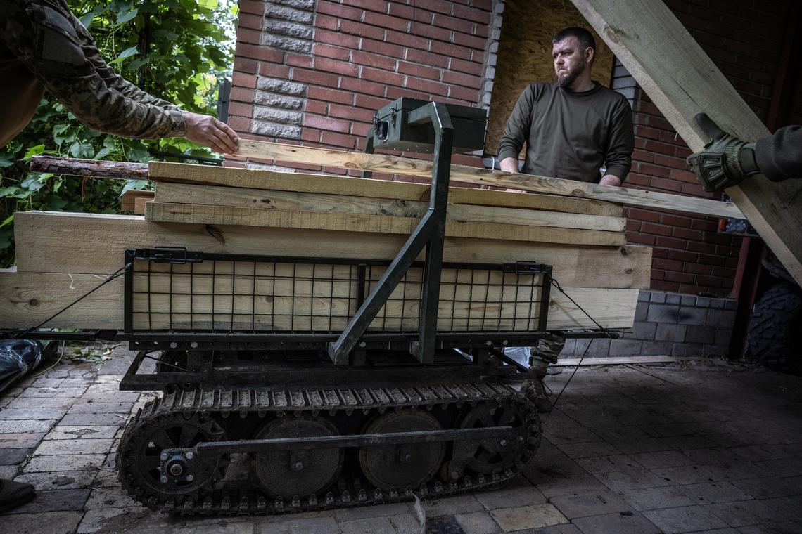 FILE -- At a forward base in Kostiantynivka, in eastern Ukraine, Ukrainian soldiers load an unmanned ground vehicle with lumber supplies for infantry troops building a bunker on the front line, June 18, 2025. Ukraine is using unmanned ground vehicles armed with bombs, guns or rockets to carry out attacks and keep its soldiers out of harm's way. (David Guttenfelder/The New York Times)