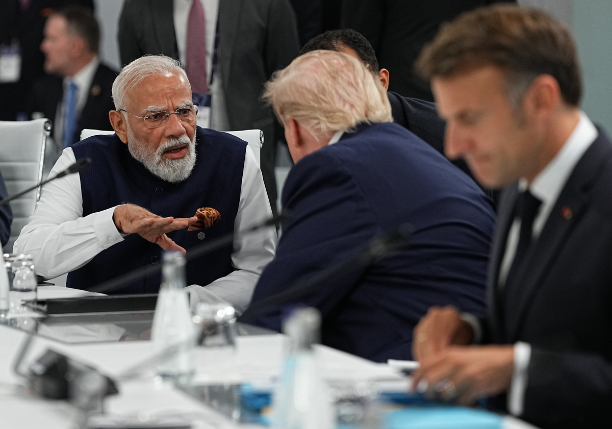 Indian Prime Minister Narendra Modi, left, and President Donald Trump, center, have a discussion as French President Emmanuel Macron, right, prepares notes at the G7 Summit in Evian-les-Bains, France, June 16, 2026. (Haiyun Jiang/The New York Times)