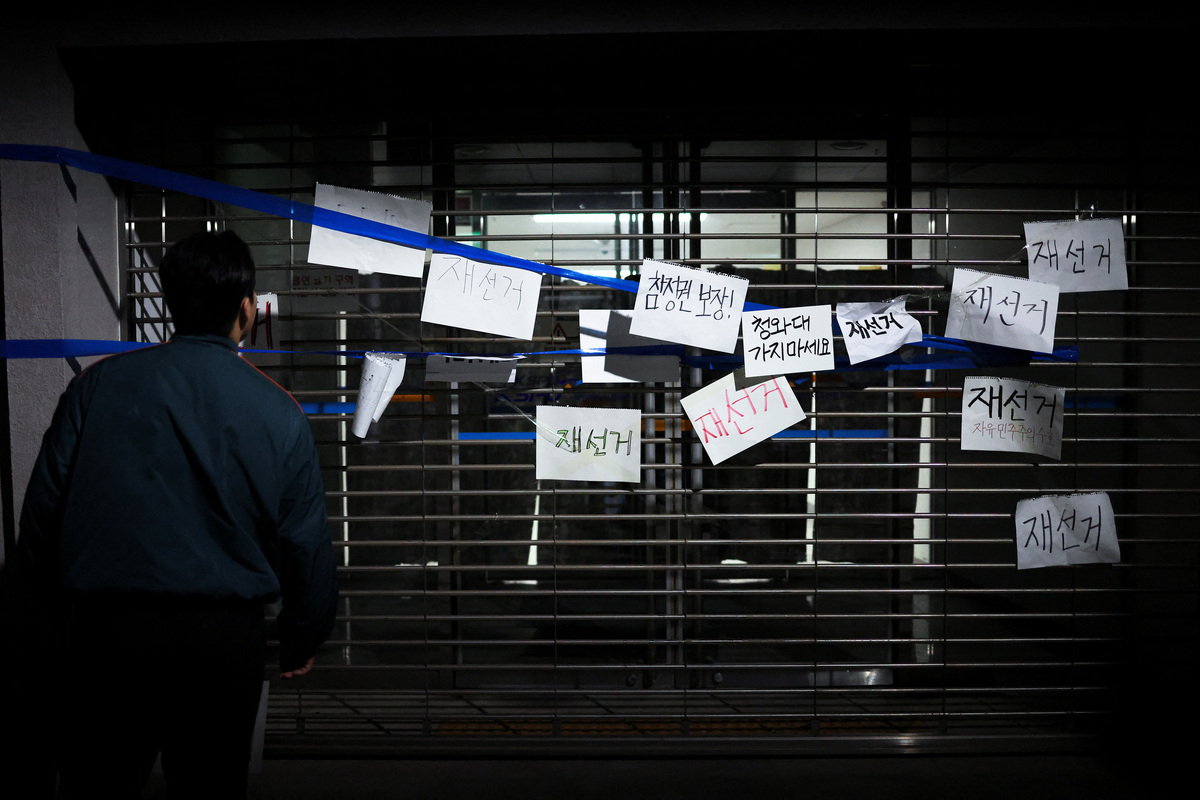 Signs reading "Rerun the election" and "Guarantee voting rights" are sticked onto a gate as people surround a vote-counting centre to protest a controversy over a shortage of ballot papers that disrupted voting in the local election and to call for a rerun of the election, in Seoul, South Korea, June 6, 2026. REUTERS/Kim Hong-Ji
