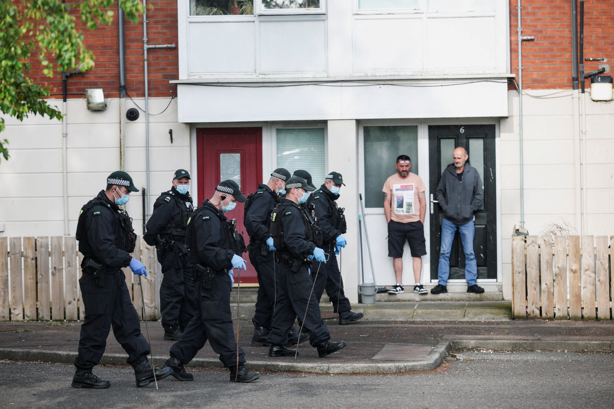 Police officers inspect the area near the scene of a stabbing outside apartments in the Kinnaird Avenue area of north Belfast, after a knife attack on June 8 left a man seriously injured and prompted police to declare a critical incident, in Belfast, Northern Ireland, June 9, 2026. REUTERS/Isabel Infantes