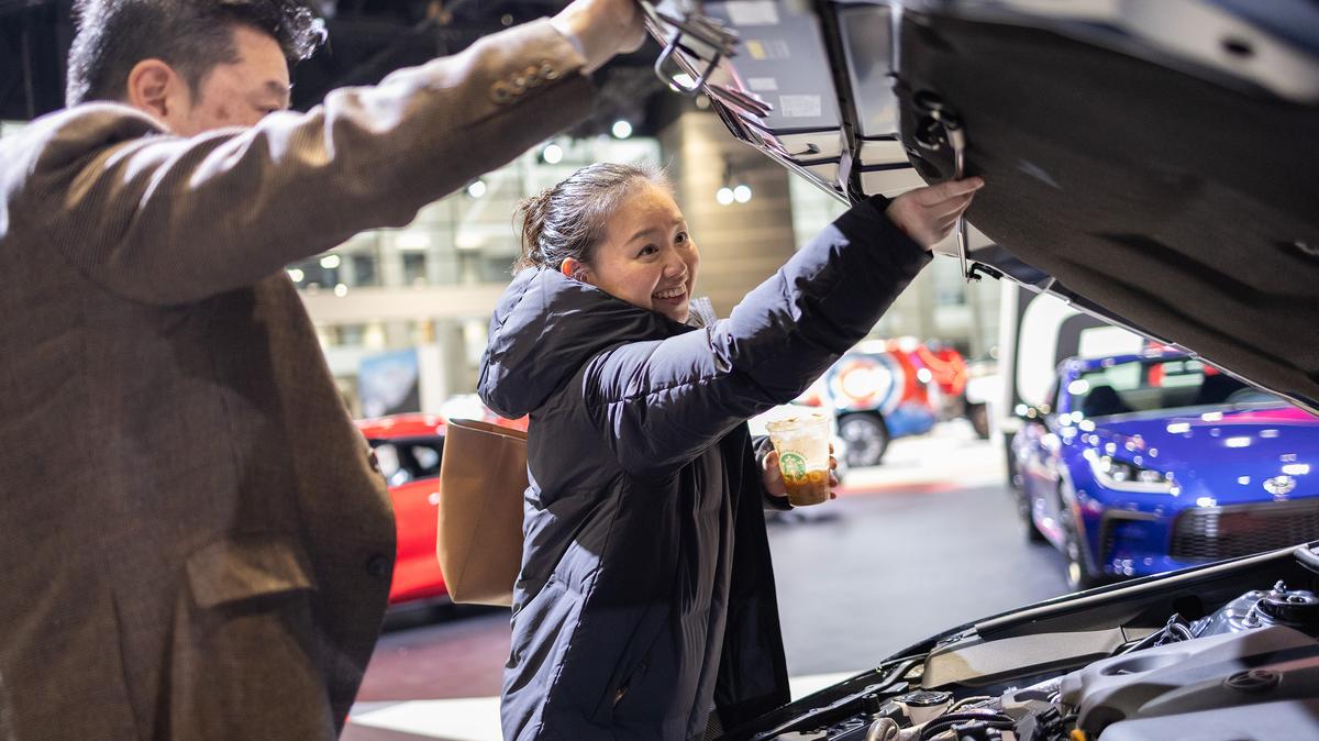 Kenta Shinohara, left, and Asae Nakagawa, both of Chicago, look at a car during media preview day at the 2026 Chicago Auto Show at McCormick Place on Feb. 6, 2026, in Chicago. (Josh Boland/Chicago Tribune/TNS)