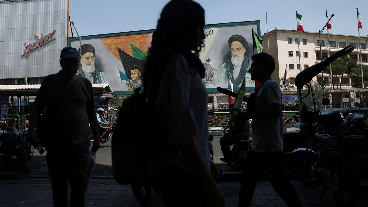People walk past a mural depicting the late leader of the Islamic Revolution, Ayatollah Ruhollah Khomeini, and the late Iran's Supreme Leader Ayatollah Ali Khamenei, on a street in Tehran, Iran, June 9, 2026. Majid Asgaripour/WANA (West Asia News Agency) via REUTERS