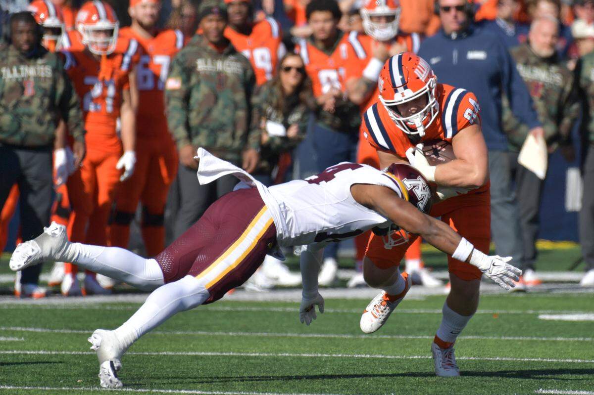 Nov. 2, 2024; Champaign, Illinois, USA; Illinois Fighting Illini tight end Carson Goda (84) is tackled by Minnesota Golden Gophers defensive back Kerry Brown (14) during the first half at Memorial Stadium.