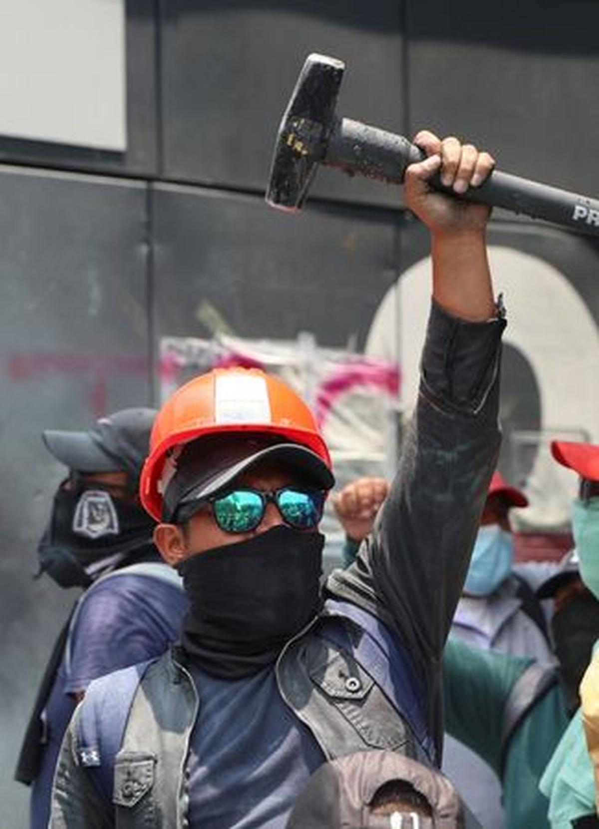 A dissident teacher from Mexico's National Coordination of Education Workers (CNTE) holds a sledgehammer as they gather outside one of the access points to the offices of the Secretariat of Public Education (SEP) during a protest to demand better wages and pensions, under the slogan "If there's no solution, the ball won't roll," ahead of the 2026 FIFA World Cup, in Mexico City, Mexico, June 3, 2026. REUTERS/Luis Cortes