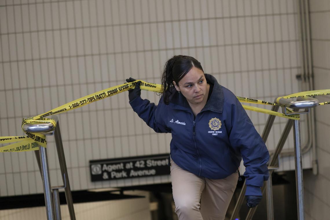 A member of the NYPD crime scene unit exits an entrance to the Subway station at Grand Central Terminal in Manhattan following a reported stabbing and police shooting on Saturday, April 11, 2026. A person was reportedly stabbed in the head on the platform of the uptown 4, 5 and 6 trains; an officer who had been called to the platform then shot the attacker. Both were in critical condition. (Heather Khalifa/The New York Times)